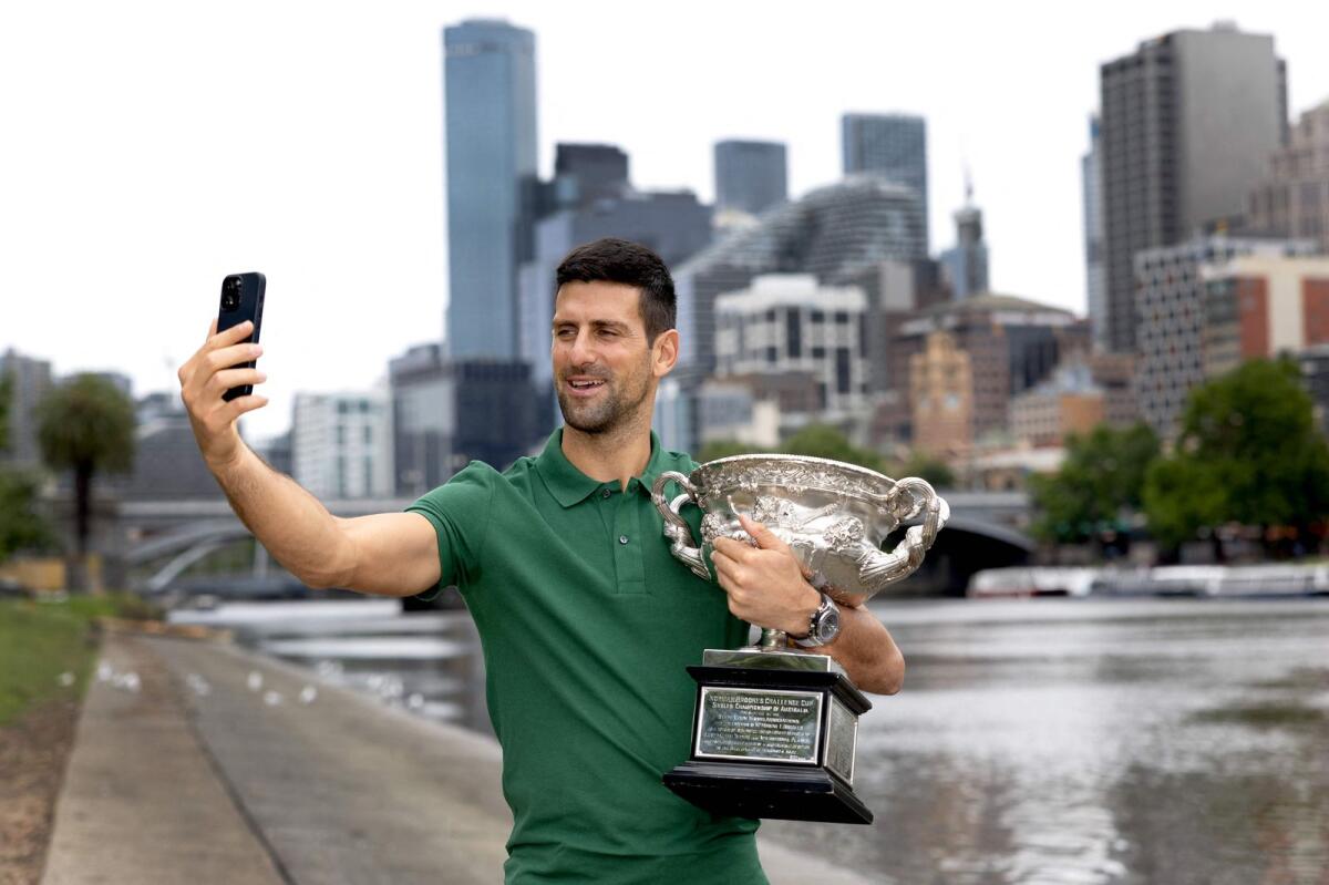 Novak Djokovic takes a selfie with the Yarra River and the Melbourne skyline in the background. — AFP