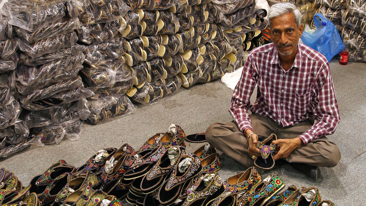 KEEPING WITH TRADITION... A shop keeper proudly displays traditional footwear sold at  Desi Punjab pavilion.