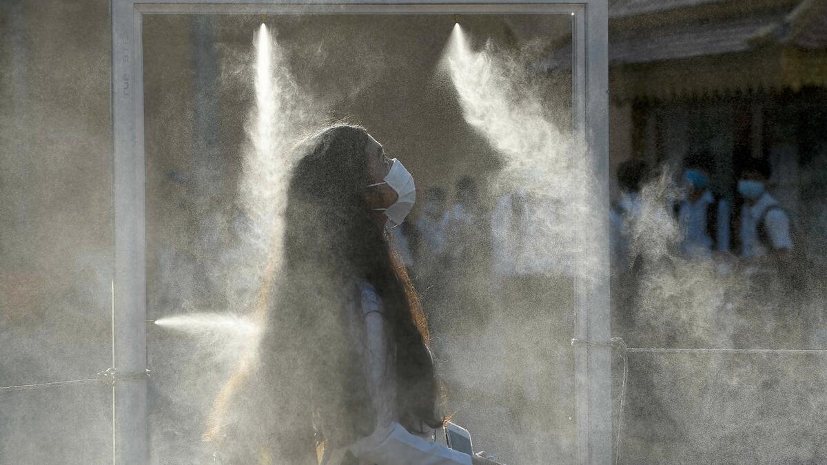 A face mask-clad student walks through a gate equipped with disinfectant spray as part of measures against the Covid-19 coronavirus in Phnom Penh, as schools reopen across the country. Photo: AFP