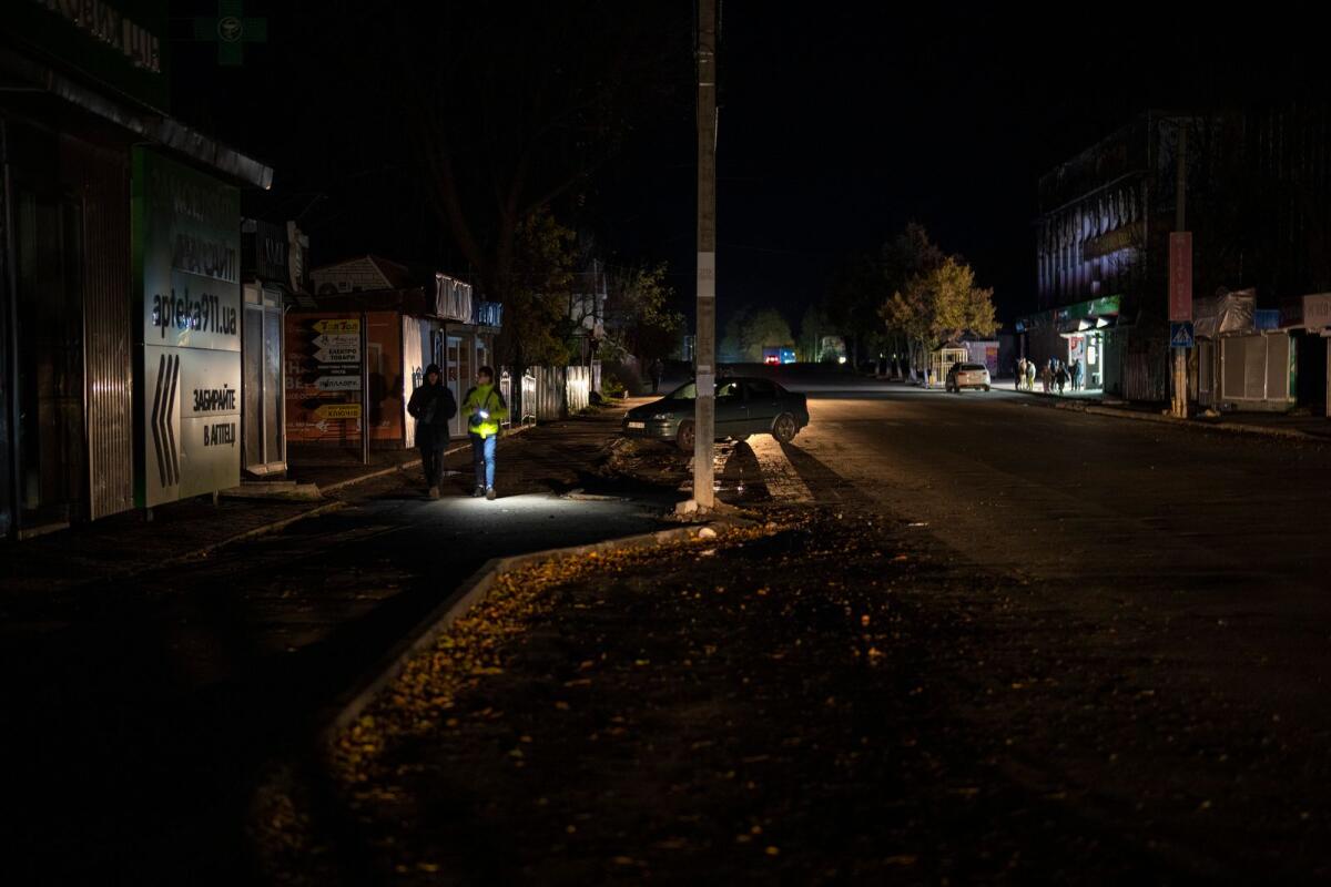People walk along a street during a power outage, in Borodyanka, Kyiv region, Ukraine, Thursday, Oct. 20, 2022. Photo: AP