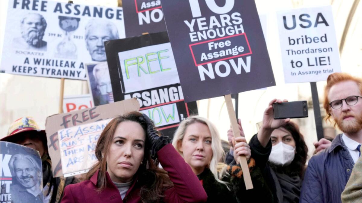Stella Moris, partner of Julian Assange, stands with protestors in front of the High Court in London. — AP