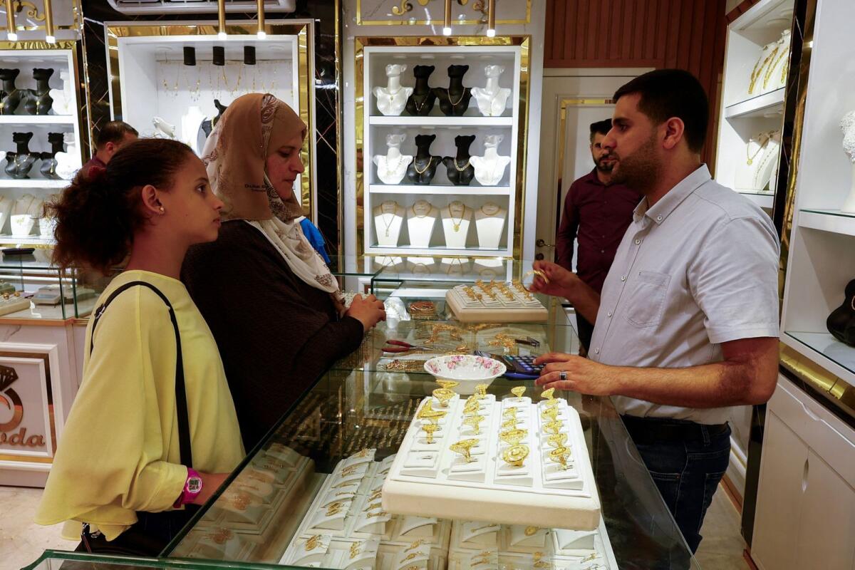 A Palestinian gold salesman sells gold pieces at a jewelry store, in Khan Younis, southern Gaza Strip on August 29, 2023. — Reuters