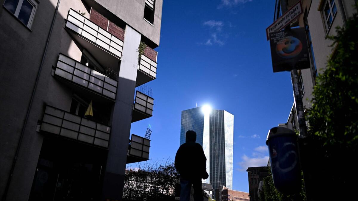 A man walks on a street with the European Central Bank (ECB) in the background in Frankfurt am Main. — AFP