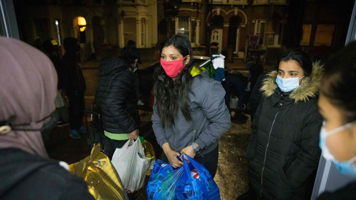 International students collect food packages from the Newham Community Project food bank in east London on February 16, 2021.