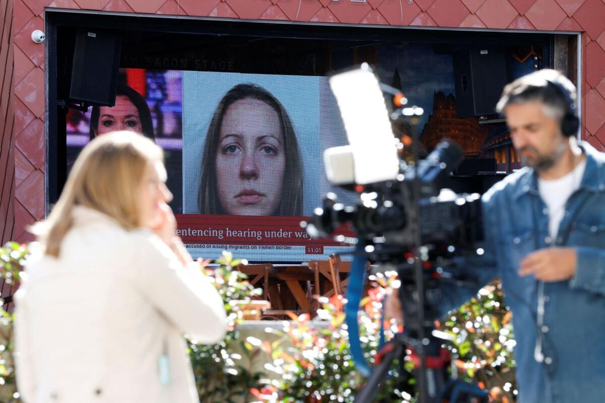 Members of the media work near a large screen showing a picture of convicted hospital nurse Lucy Letby ahead of her sentencing,outside the Manchester Crown Court in Manchester, Britain, on August 21, 2023. — Reuters