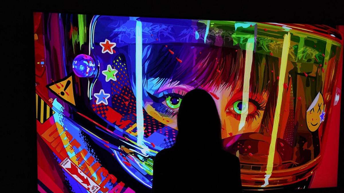 A woman looks at a NFT by Mad Dog Jones titled  'SHIFT//' during a media preview at Sotheby's. — AFP file photo