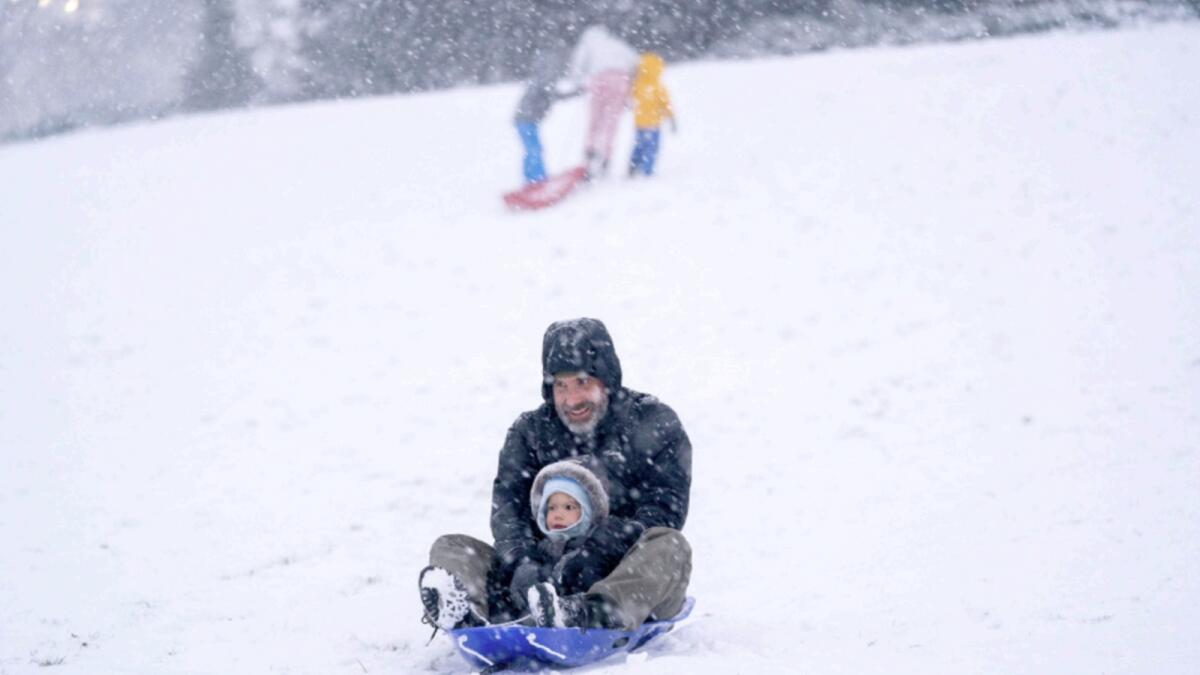 Families take advantage of a winter storm to sled at Capitol Hill in Washington, DC. — AFP