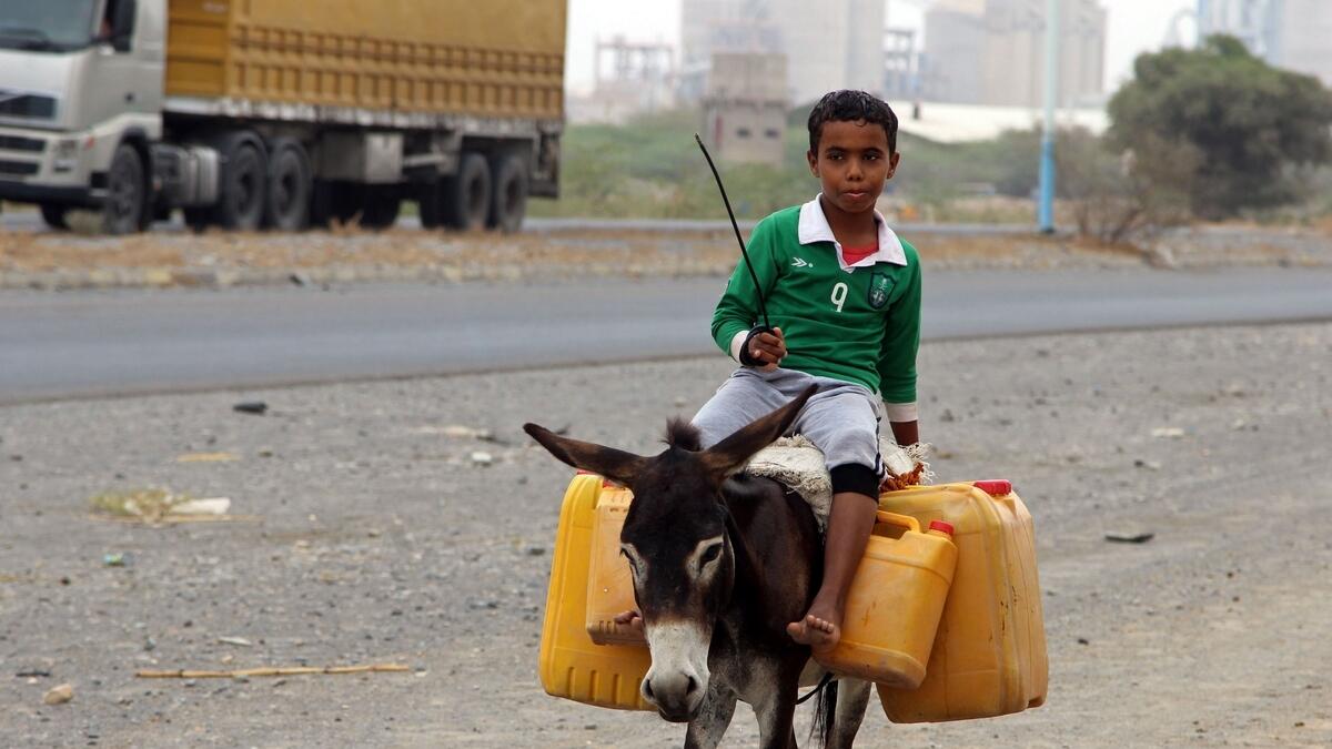 A Yemeni boy rides a donkey carrying plastic containers full of water in an impoverished coastal village on the outskirts of the Yemeni port city of Hodeidah.- AFP