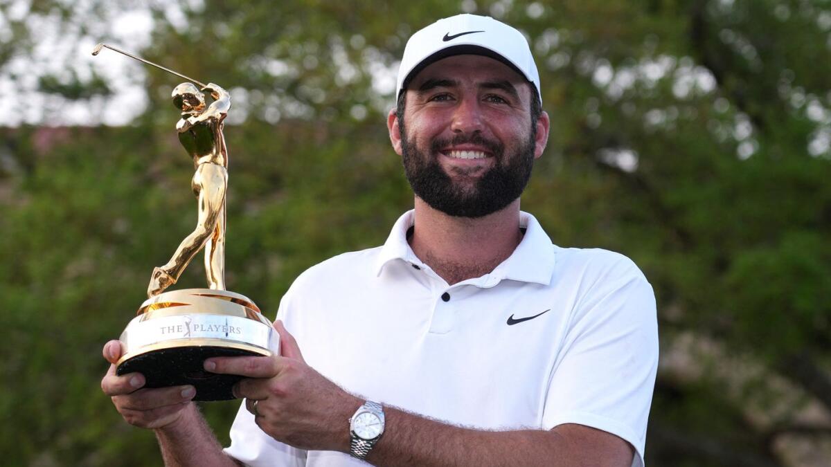 Scottie Scheffler poses with the Champions trophy after winning The Players Championship golf tournament. - USA TODAY Sports