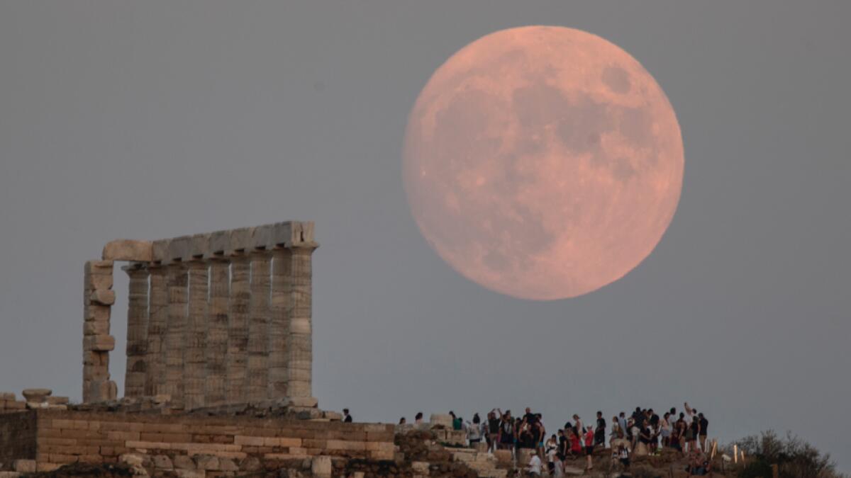 The moon rises behind the columns of the ancient marble Temple of Poseidon at Cape Sounion, south-southeast of Athens. Photo: AP