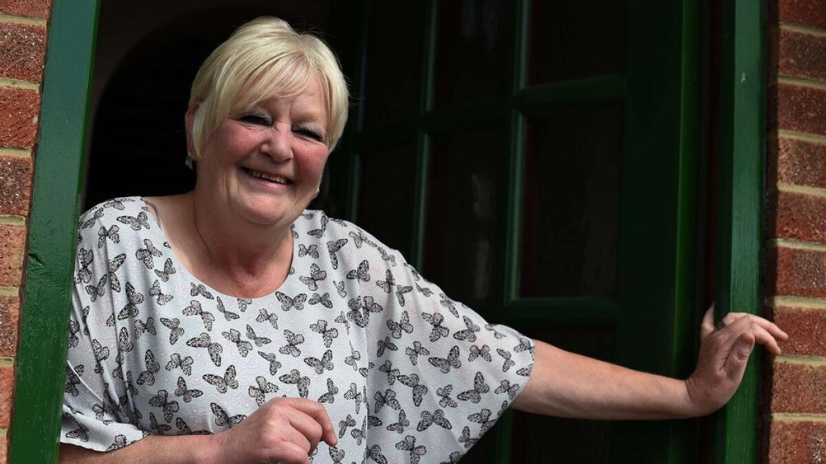 Lynne Love stands on her doorstep in Derby, central England. 