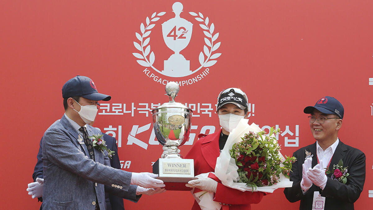 South Korea's Park Hyun-kyung wearing a face mask of holds the trophy after winning the KLPGA Championship. -- AP