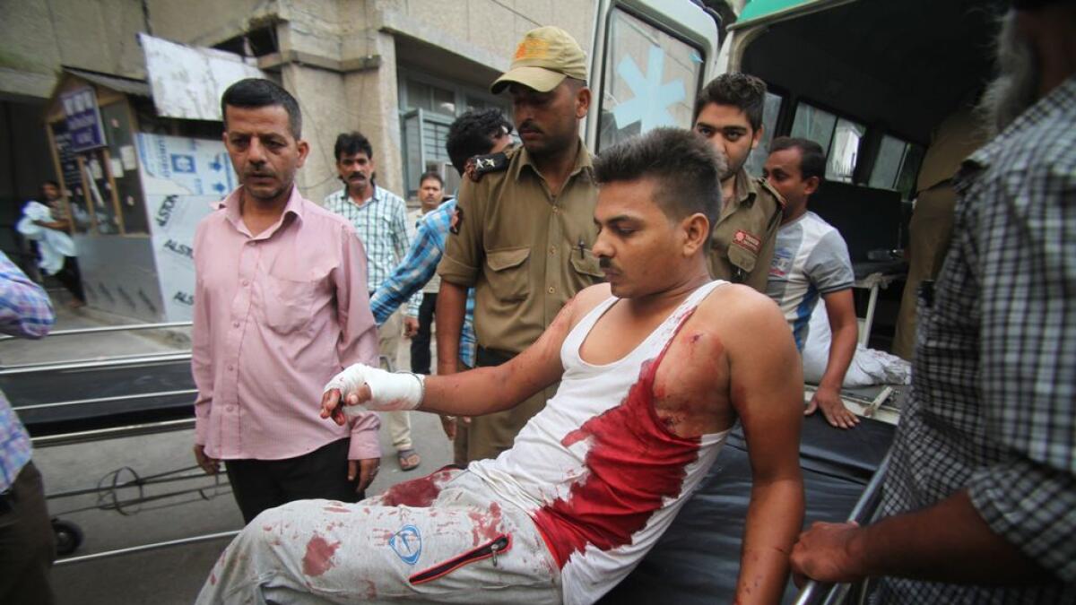 An injured Indian civilian of cross border firing gets down from an ambulance at the Government Medical College hospital in Jammu, India.