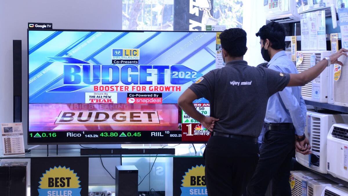 Staff at an electronics goods showroom watch the telecast of union budget being presented by India's Finance minister on the displayed television sets at a showroom in Mumbai on Tuesday. — AFP