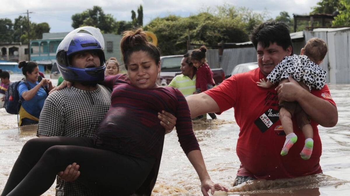 A pregnant woman is carried out of an area flooded by water brought by Hurricane Eta in Planeta, Honduras, Thursday, Nov. 5, 2020.