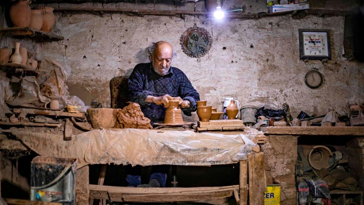 Syrian-Armenian potter Misak Antranik Petros uses an ancient pottery wheel to churn different types of pots at his workshop located inside an ancient mud-brick house near the city of Qamishli in Syria's northeastern Hasakeh province.