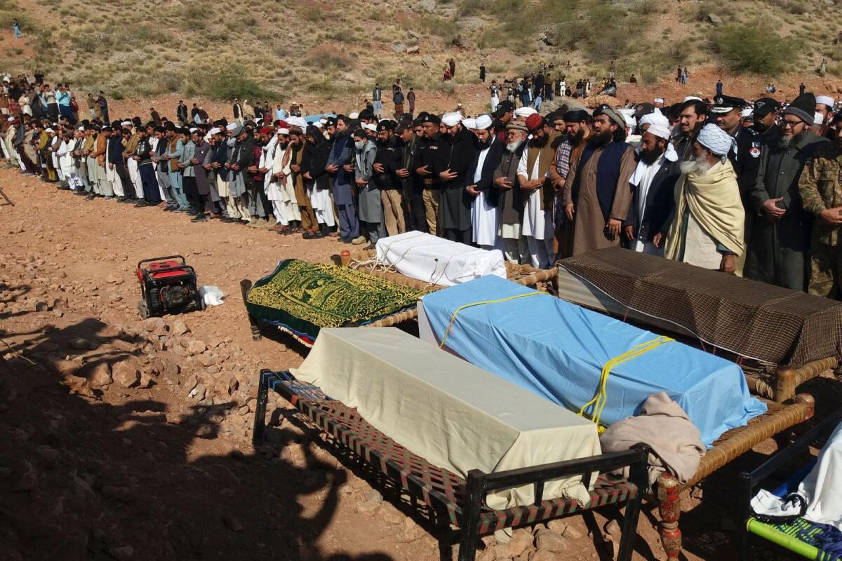 Relatives and local residents offer funeral prayers for students who drowned after a boat capsized in Tanda Dam. Photo: AFP