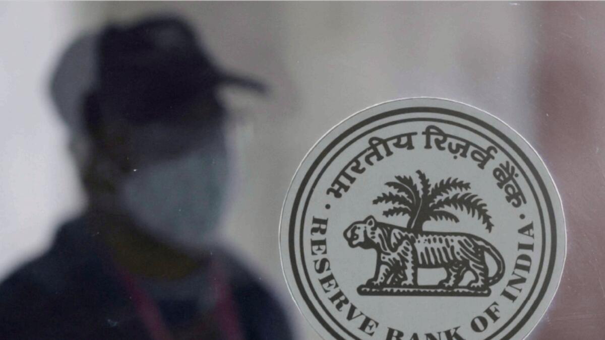 A man walks behind the Reserve Bank of India logo inside its headquarters in Mumbai. — Reuters file