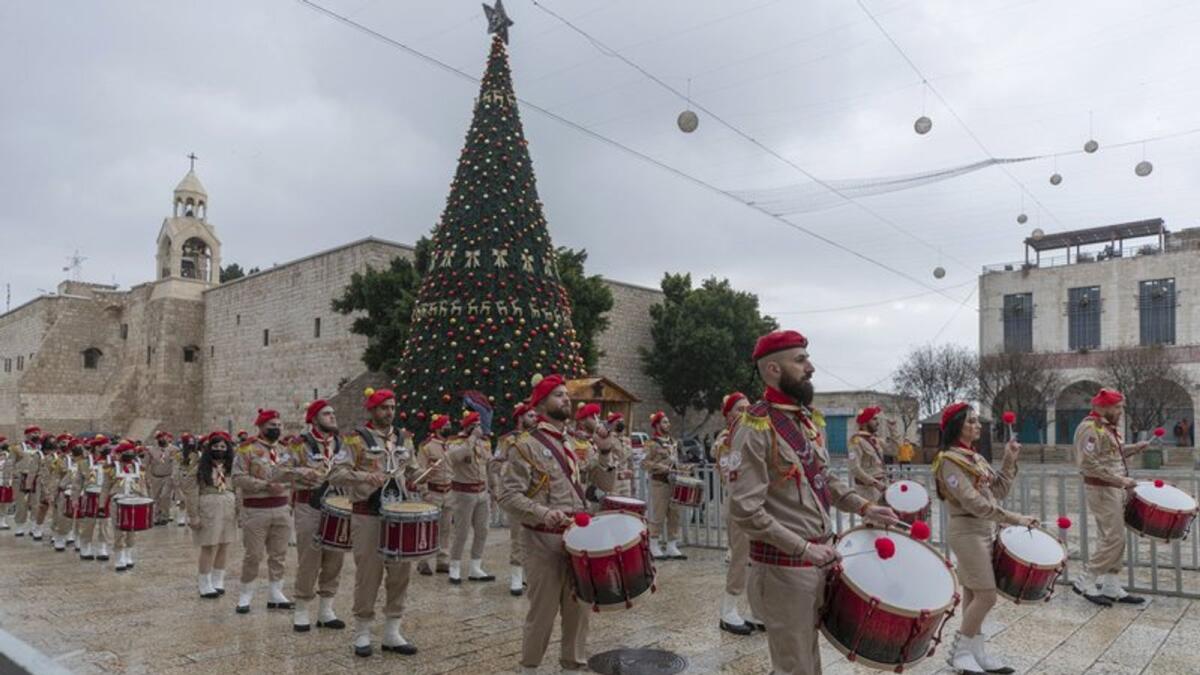 Palestinian scout bands parade through Manger Square at the Church of the Nativity, traditionally recognised by Christians to be the birthplace of Jesus Christ, ahead of the midnight Mass, in the West Bank city of Bethlehem, Thursday, Dec. 24, 2020
