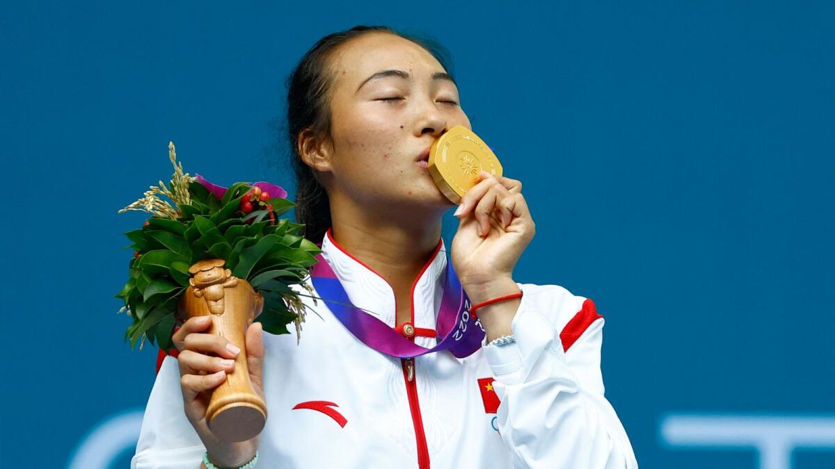 China's Zheng Qinwen poses with her gold medal after winning the women's tennis final - Reuters