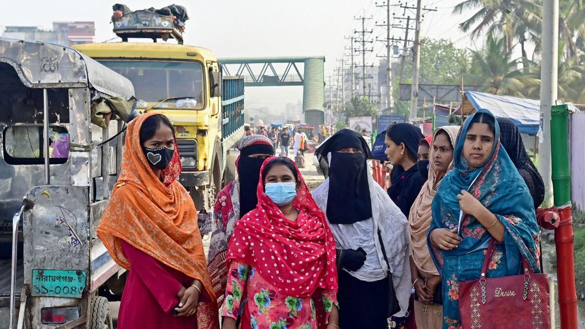 In this photograph taken on April 13, 2023, women wait in front of a garment factory to be called for recruitment in Savar, on the outskirts of Dhaka.  — AFP file