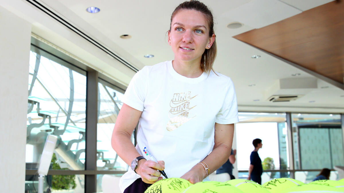 Halep signs autographs on large-sized tennis balls ahead of the DDF Tennis Championships. Halep said she was nervous as she practiced against Kim Clijsters, who is making a second comeback. — Photo by Juidin Bernarrd