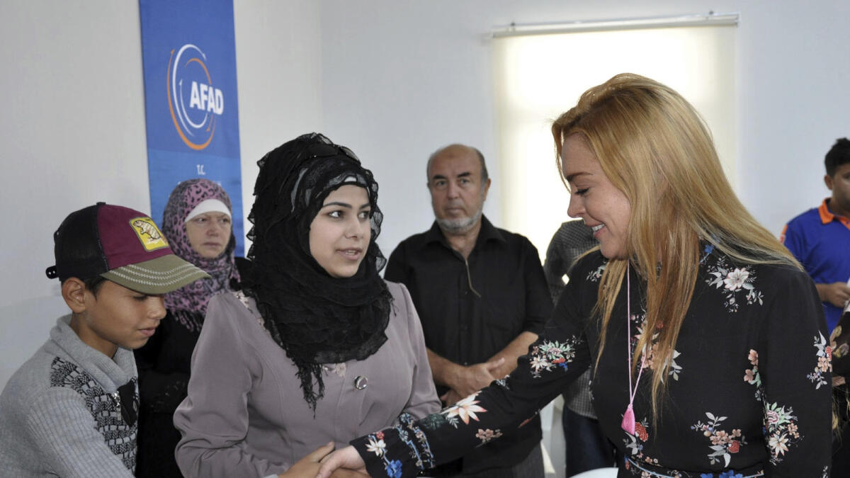 U.S. actress Lindsay Lohan gives presents to Syrian refugee children as she visits a Turkish government-run Syrian refugee camp in Nizip.