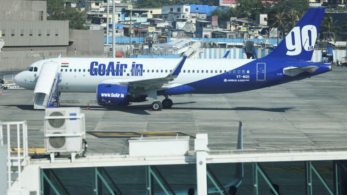 People wait in line on a passenger boarding bridge next to a Go First airline passenger aircraft parked at the Chhatrapati Shivaji International Airport in Mumbai, India, on May 3, 2023. Photo: Reuters