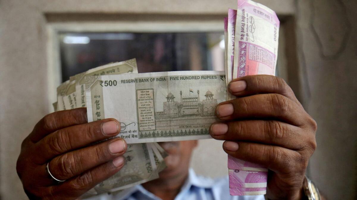 A cashier checks Indian rupee notes inside a room at a fuel station in Ahmedabad. - Reuters file