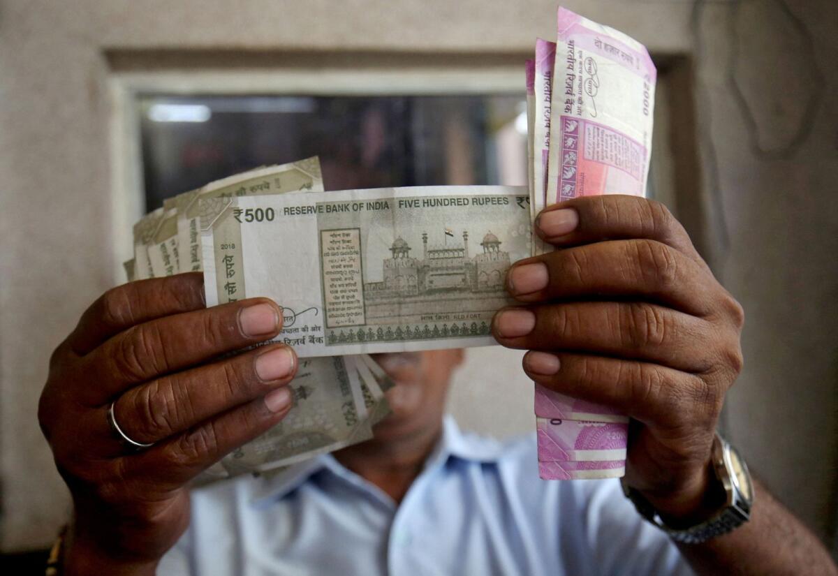 FILE PHOTO: A cashier checks Indian rupee notes inside a room at a fuel station in Ahmedabad, India, September 20, 2018. Photo: Reuters