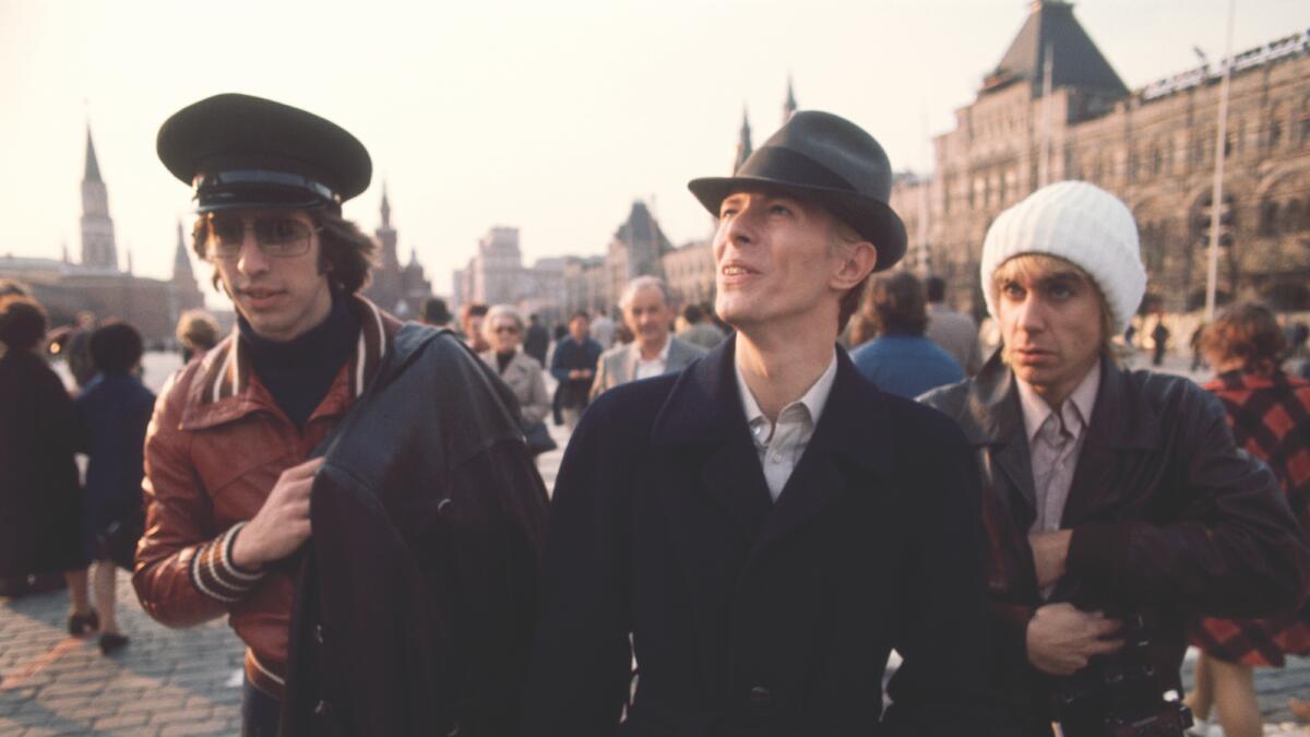 David Bowie strolls about Moscow’s Red Square with Iggy Pop and manager Pat Gibbons (1976)