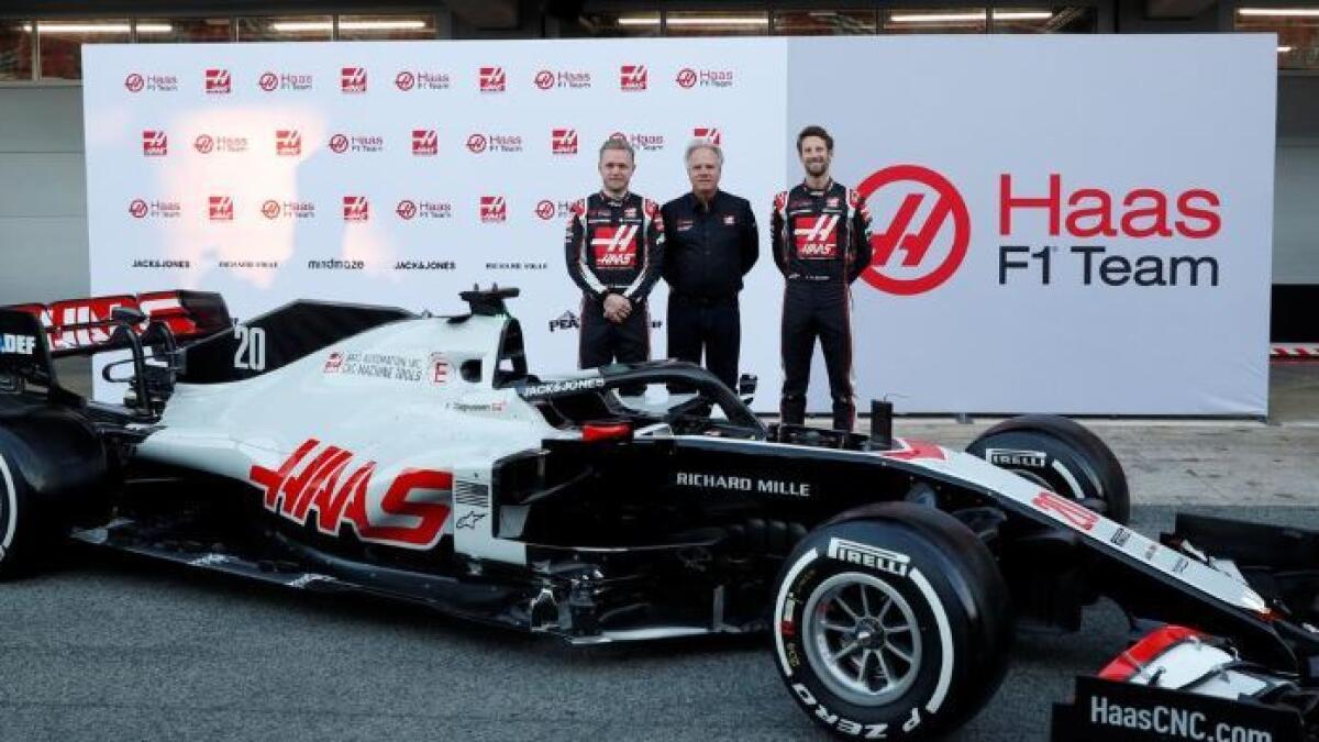 Haas' Kevin Magnussen and Romain Grosjean pose with the team owner Gene Haas alongside the new car (Reuters)
