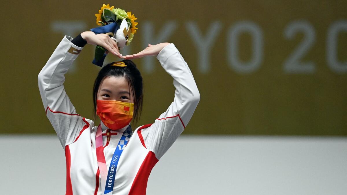 China's Yang Qian celebrates on the podium after winning the women's 10m air rifle final at the Tokyo 2020 Olympic Games. Photo: AFP