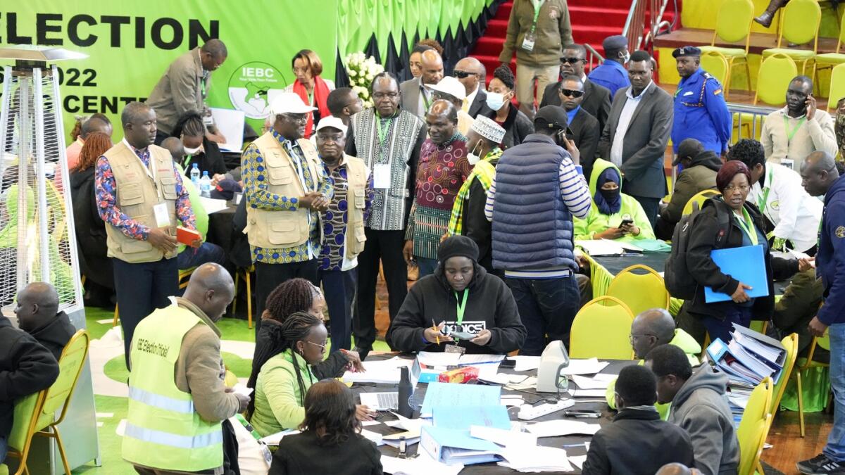 Electoral Commission Chairman, Wafula Chebukati, middle in red shirt, and IEBC commissioners at the National Tallying Centre in Bomas of Kenya, Nairobi, on Sunday. — AP