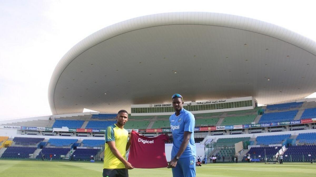 Subait Khater with the West Indies captain jason Holder at the Shaikh Zayed Cricket Stadium.