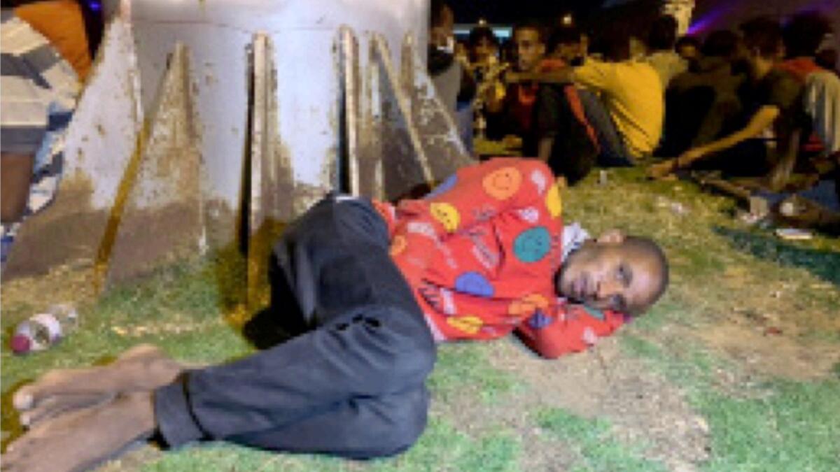 A migrant lies after he was detained by Libyan security forces in Tripoli. — Reuters