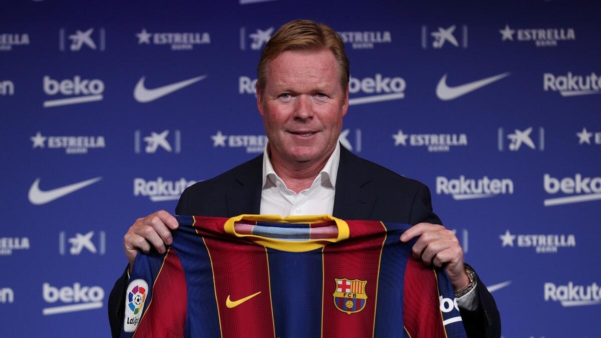 Ronald Koeman poses with a Barcelona shirt at a press conference on Wednesday. (Reuters)