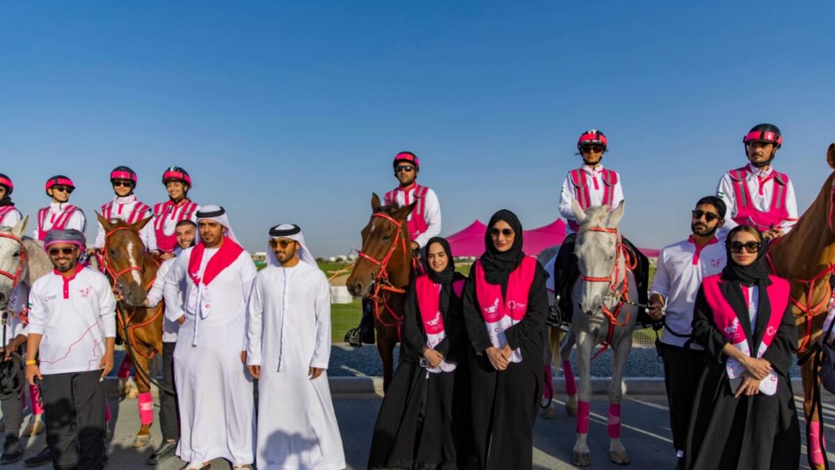 Group image of The Pink Caravan riders with Sheikh Abdullah bin Majid Al Nuaimi, Director General of Citizens Affairs Office in Ajman