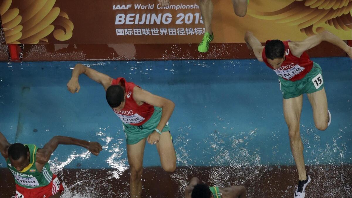 Competitors take the water jump in the men?'s 3000m steeplechase final at the World Athletics Championships at the Bird's Nest stadium in Beijing, on Aug. 24, 2015. 