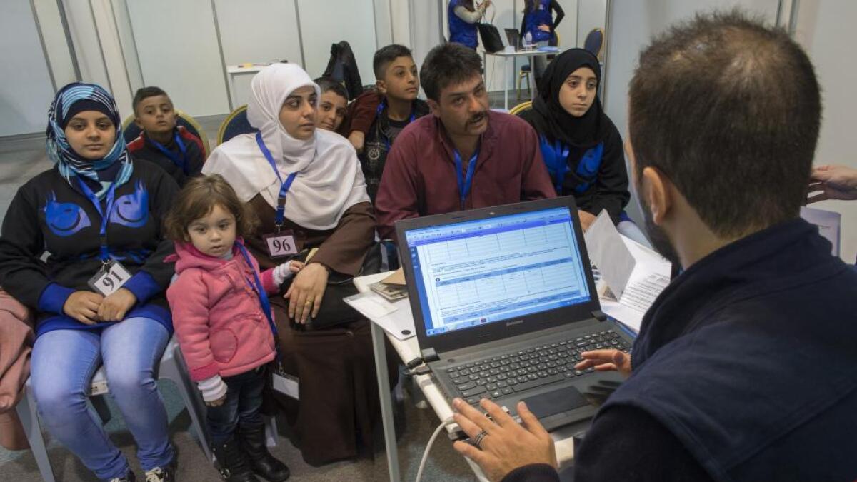 A family of Syrian refugees being interviewed by authorities in hope of being approved for passage to Canada at a refugee processing centre in Amman, Jordan.