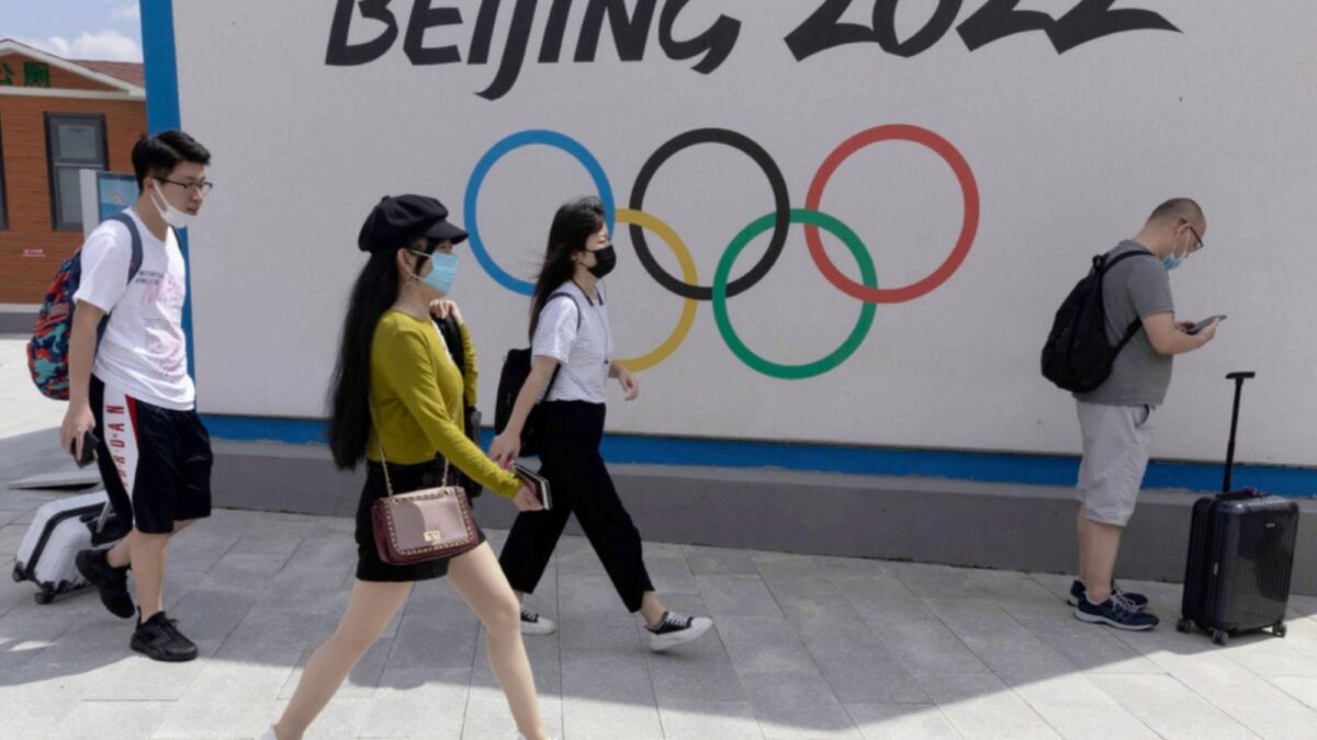 Visitors to Chongli, one of the venues for the Beijing 2022 Winter Olympics, pass by the Olympics logo in Chongli in northern China's Hebei Province. — AP file