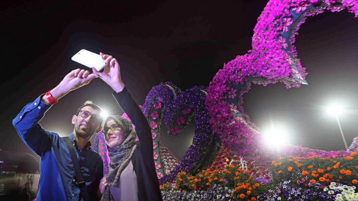 Visitors taking a selfie in front of the heart shaped flower installation at the Miracle garden in Dubai. -Photo by Dhes Handumon/ Khaleej Times 