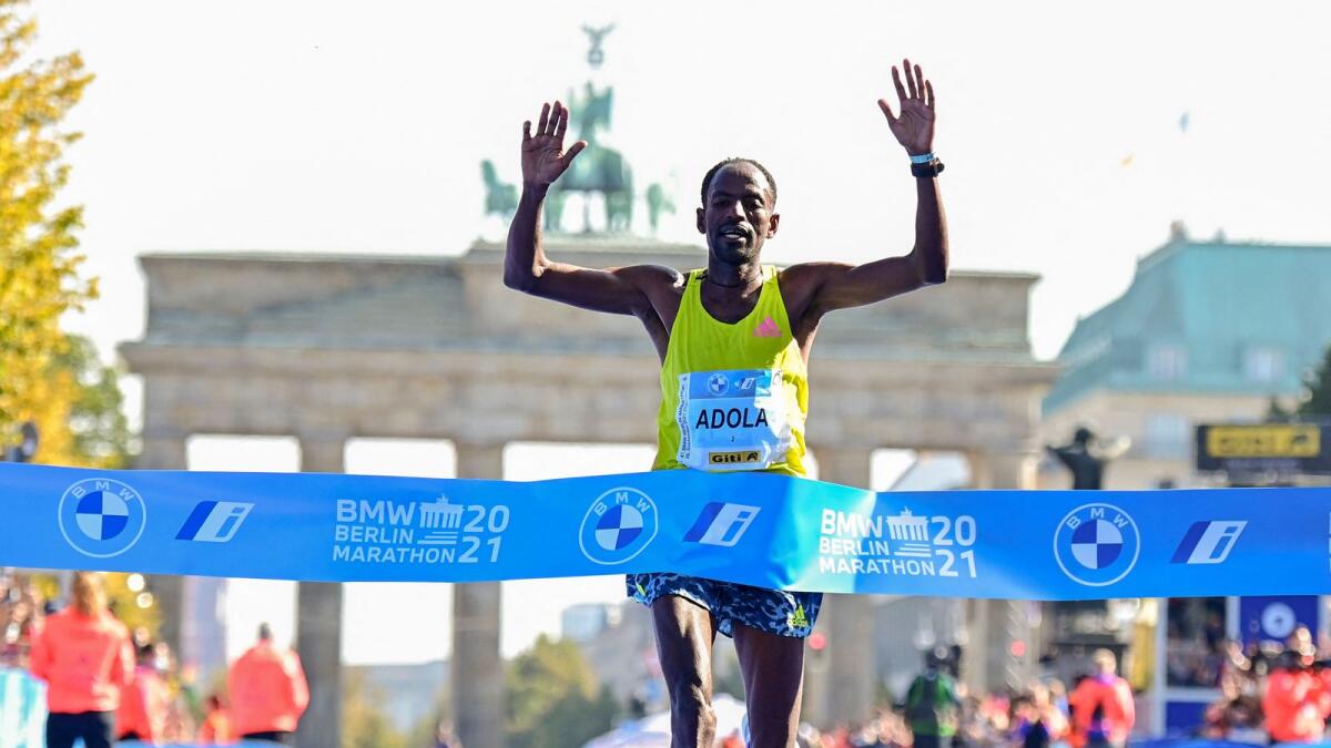 Ethiopia’s Guye Adola crosses the finish line to win the Berlin Marathon on Sunday. — AFP