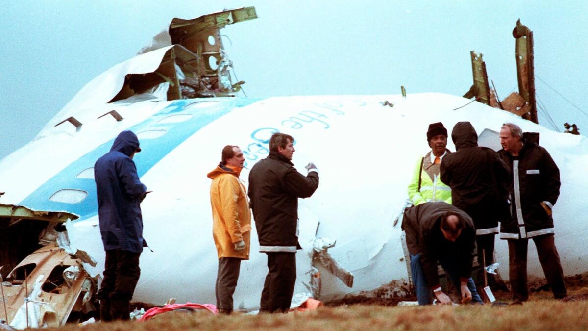 Unidentified crash investigators inspect the nose section of the crashed Pan Am flight 103 in a field near Lockerbie, Scotland, Dec. 23, 1988. — AP file