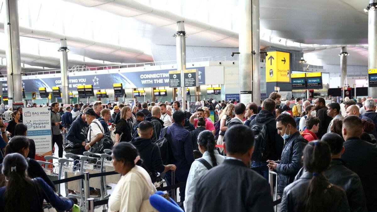 Passengers queue inside the departures terminal of Terminal 2 at Heathrow Airport in London. — Reuters file