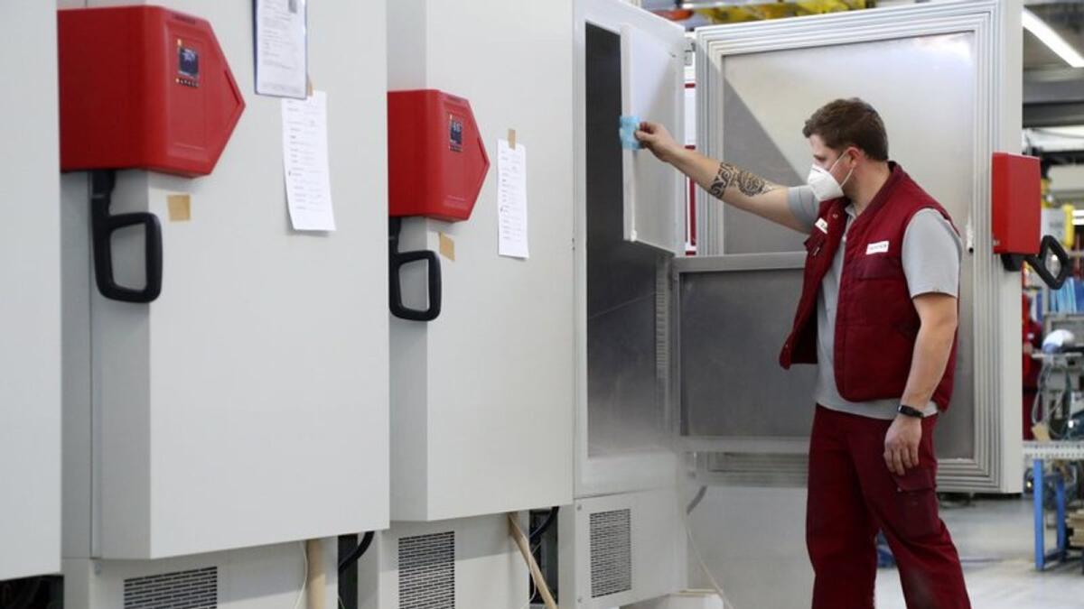 In this Tuesday, Nov. 24, 2020 file photo an employee of Binder, the world's largest manufacturer of serial-production environmental simulation chambers for scientific or industrial laboratories, checks an ultra low temperature freezer in Tuttlingen, Germany.
