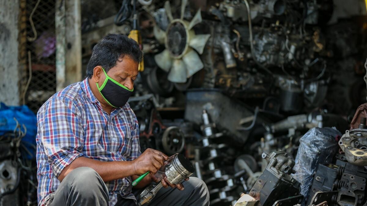 A man wearing a face mask as a preventive measure against coronavirus while working at a workshop in Sharjah.