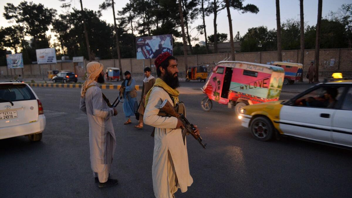 Taliban fighters stand guard along a road in Herat. Photo: AFP