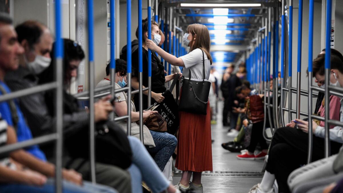 People wearing protective mask stand inside a Moscow subway train. Authorities in Moscow have issued sweeping fines for violating face mask and glove requirements in recent weeks as the city looks to enforce coronavirus safety rules. Photo: AFP