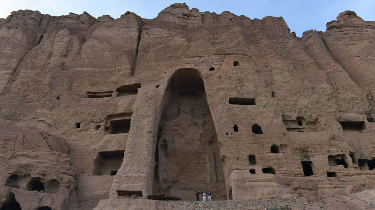 In this photo taken on June 19, 2015, visitors walk in front of the empty site of two Buddha statues, which were destroyed by the Taliban, in Bamiyan. Bamiyan -- famous for empty hillside niches that once sheltered giant Buddha statues -- is a rare oasis of tranquillity. (Photo: AFP)